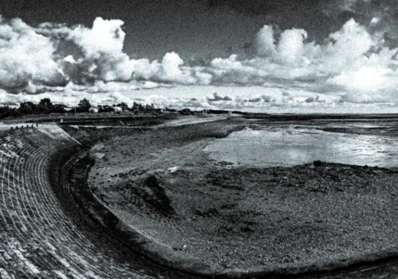 Rivage en noir et blanc sous un ciel de nuages
