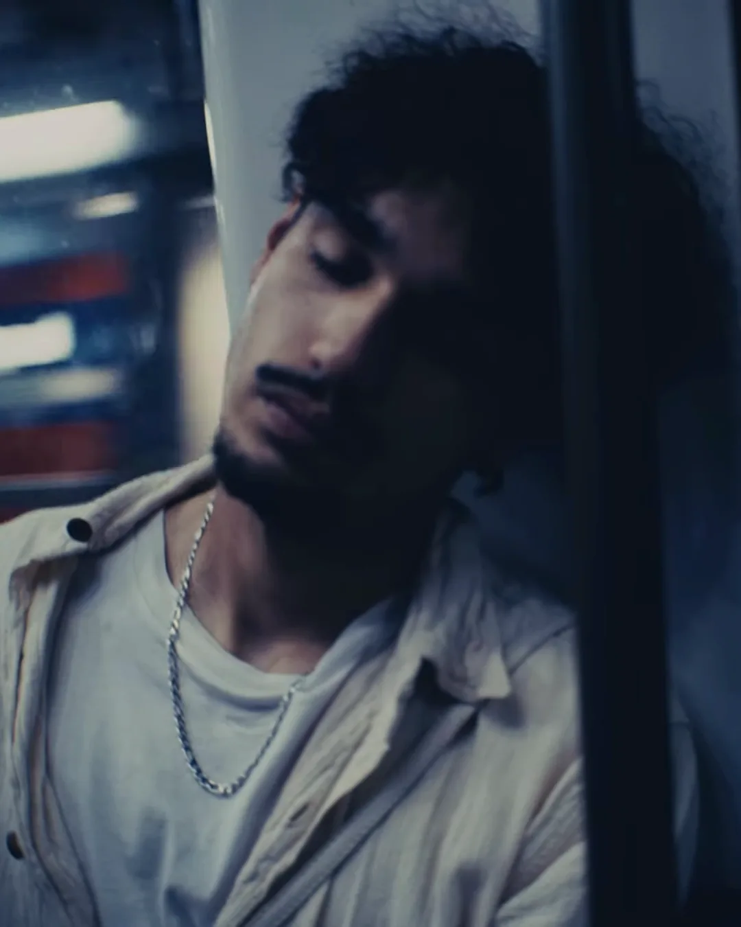 Un jeune homme les yeux fermés dans le métro, lumière bleue, Une douche sous le ciel bleu